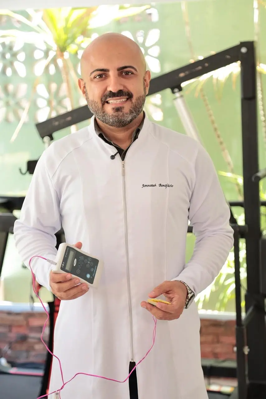 Fisioterapeuta segurando o dispositivo de estimulação transcraniana por corrente contínua (tDCS).